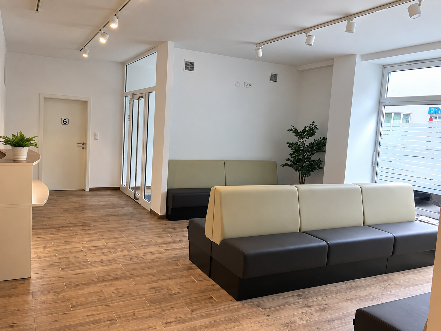 Wartebereich der Ordination mit Ledersofas und Holzboden